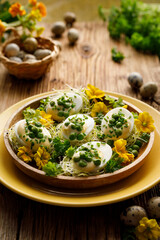 Hard-boiled eggs divided into halves with the addition of mayonnaise and green peas sprinkled with fresh chives on a decorated plate, focus on the egg inside. Easter food  - 490159474