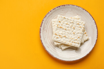 Plate with Jewish flatbread for Passover on color background