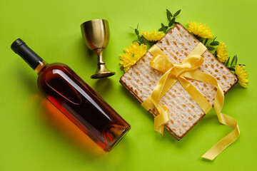 Fototapeta na wymiar Jewish flatbread with goblet and bottle of wine on color background