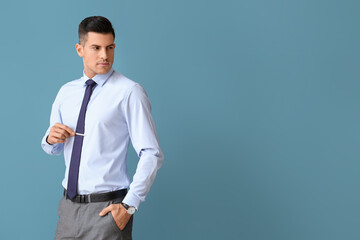 Handsome man in formal clothes looking aside on color background