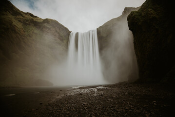 Natural view of the Skougafoss waterfall in Iceland under a gloomy sky