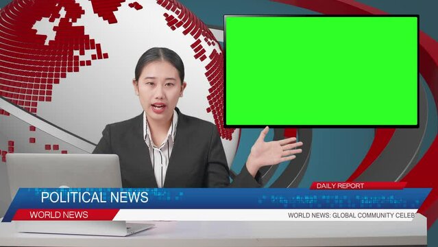Live News Studio With Asian Professional Female Anchor, Computer, And Green Screen Television Pointing To Side While Reporting On The Events Of The Day
