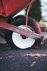 Close-up shot of a flat tire of a red wheel barrow