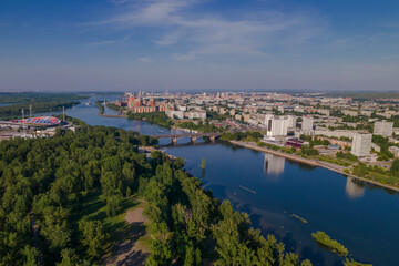 Naklejka na ściany i meble View of the city from a height, a wide river, a bridge, a view from a drone
