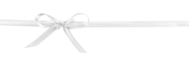 Satin ribbon with bow on white background, top view