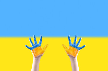Children's hands are painted in the colors of the Ukrainian flag reaching up against the background of the Ukrainian flag. Request for help. Please stop the war. No war.