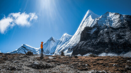 Beautiful shot of the mountain landscape and the person in orange parka © 阿 亦/Wirestock