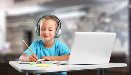 Serious focused preschooler learning online through video chat on a laptop. Child studying computer...