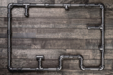 Frame. Background. Cast iron pipes and fittings of different shape, laying as a frame on a rustic...