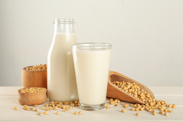 Fresh soy milk and grains on white wooden table