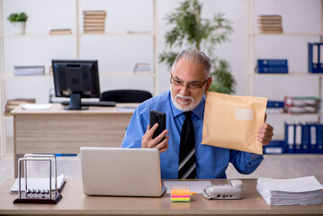 Old male employee receiving parcel via Internet