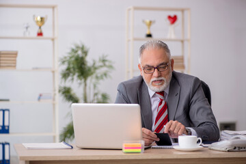 Old male bookkeeper working in the office