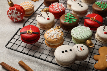 Beautifully decorated Christmas macarons on light grey table, closeup