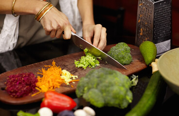 Preparing a healthy meal. Cropped image of a woman preparing dinner at home.