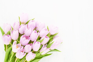 Obraz na płótnie Canvas Bouquet of lilac tulips on a white wooden background. Mothers Day, Valentines Day, birthday concept