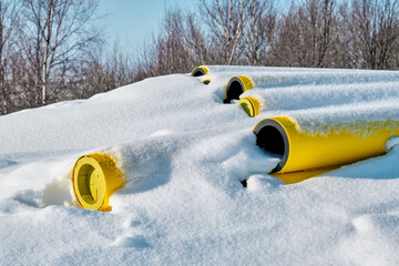 Gas pipes on a construction site under the snow.