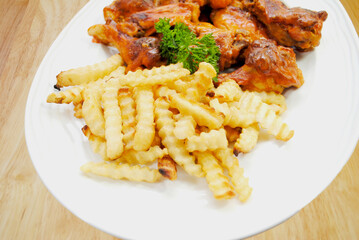 A Platter of French Fries Served and Spicy baked Buffalo Wings
