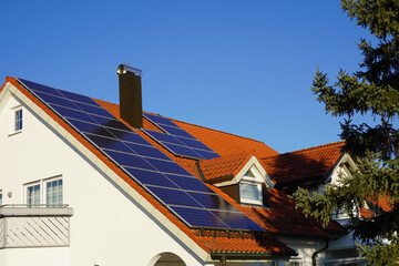 Photovoltaik Panele auf einem luxuriösem Landhaus. Auch im Winter scheint die Sonne und Solarzellen erzeugen Energie.  - obrazy, fototapety, plakaty