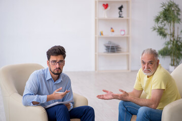 Old man visiting young male psychotherapist