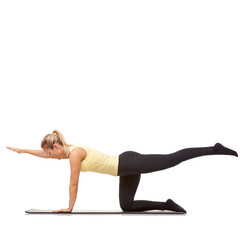 Experienced at exercise. A fit young woman doing stretches and working out on her exercise mat.