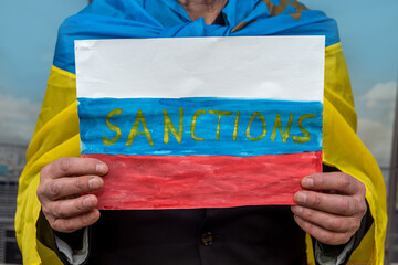 Ukraine man holding poster with message economic sanctions for Russia