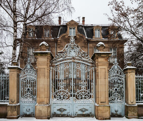 An old manor with beautiful gates is covered with snow. - 490176062