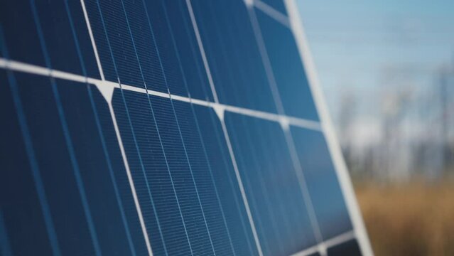 Close up of Solar photovoltaic panel with substation in background shot in 4k super slow motion