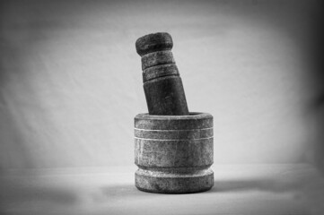 Grayscale shot of a mortar and pestle.