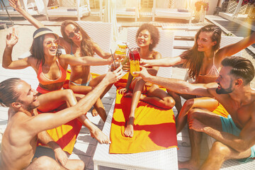 Group of friends with swimsuit drink a cocktail in a beach place