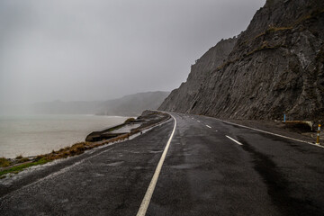 Coastal road on a stormy day at Cape Palliser near Wellington, New Zealand.