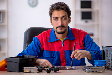 Young male repairman repairing computer