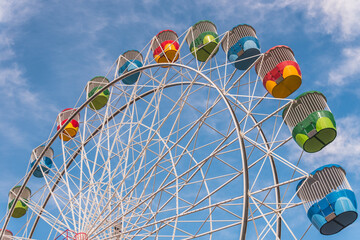 Happy Ferris wheel with colorful cabins in the amusement park