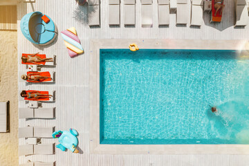 Drone view of people who relaxing in a swimming pool from