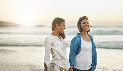 The beach teaches you something about communication. Shot of a loving couple walking hand in hand on the beach.