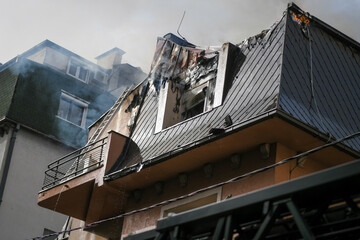 Rooftop of residential house/building on fire and burning down. Burning fire smoke blaze.