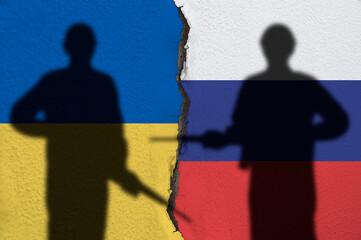 Flag of Ukraine and Russia painted on a concrete wall with soldiers shadows. Relationship.between...