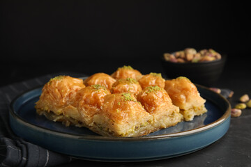 Delicious sweet baklava on black table, closeup