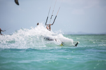 Kitesurfing, kiteboarding in exotic location, tropical island. Kitesurfer activities.