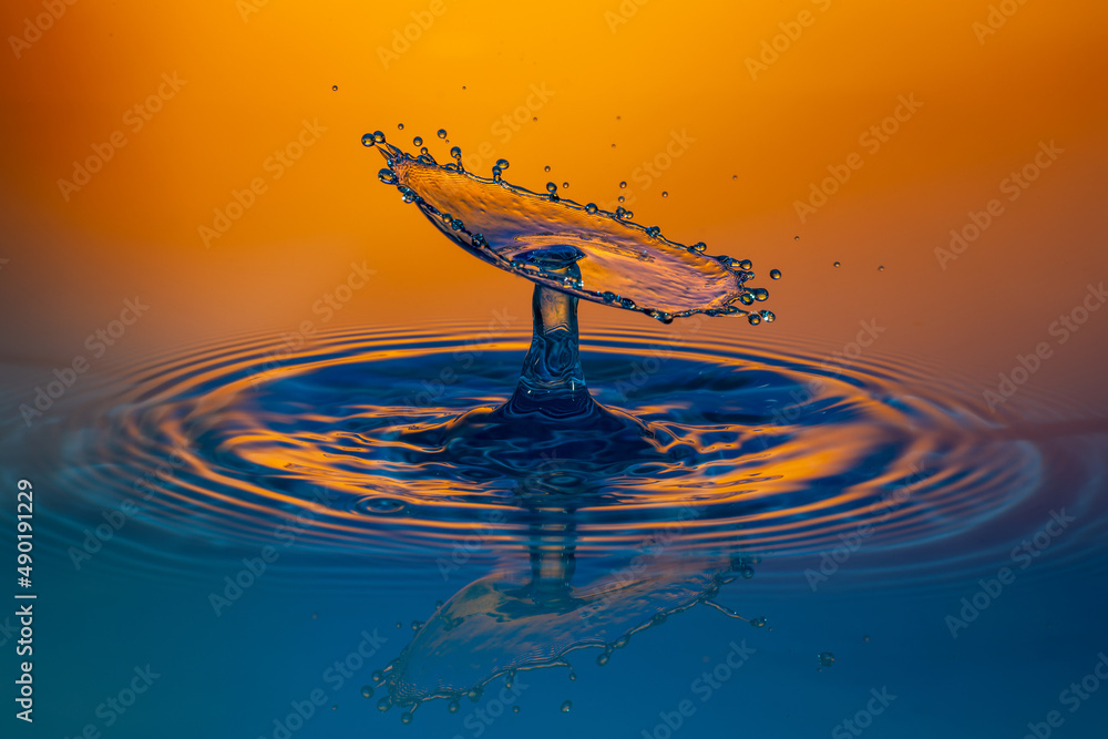 Sticker close-up shot of a water splash in a blue tone with orange background