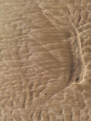 Vertical top view of the textured sand on the beach