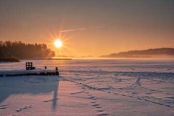 Sunrise view over the snowy and frozen ground of the field