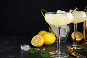 Delicious bee's knees cocktails and ingredients on black table. Space for text