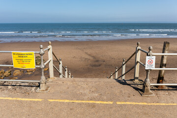Stairway going down into the seashore under a blue sky