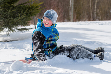 Fototapeta na wymiar Snow-covered Boy Playing in the Snow