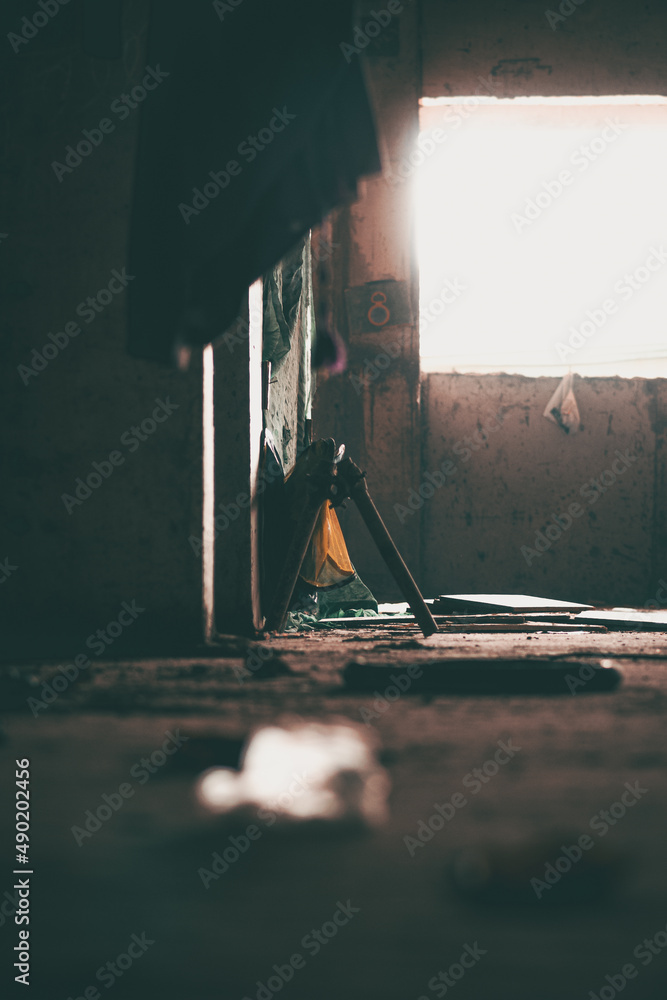 Poster vertical shot of the empty grungy room with a window.
