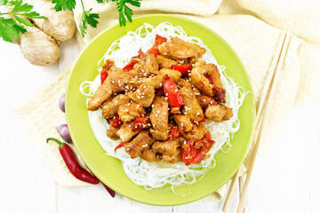 Stir-fry of chicken with peppers in plate on board top