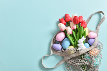 Obraz premium A beautiful bouquet of tulips with a string bag containing painted eggs.