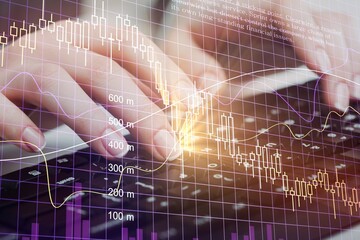 Programmer working on laptop computer with financial graph, big data, technology background.