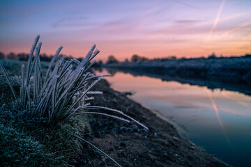 Scenic view of a narrow creek in a middle of a field during a beautiful sunset