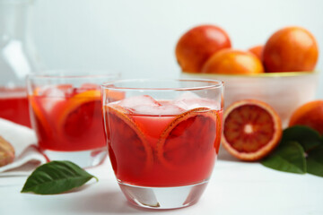 Tasty sicilian orange juice with ice cubes and fruits on white table